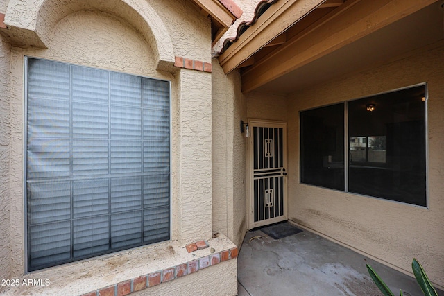 view of exterior entry featuring stucco siding