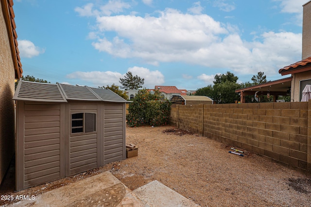 view of yard with a fenced backyard, an outdoor structure, and a shed