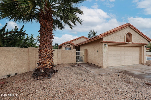 view of front facade featuring stucco siding, an attached garage, a gate, fence, and driveway