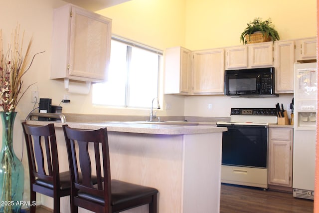 kitchen with white appliances, dark wood-style floors, a breakfast bar, a peninsula, and light countertops