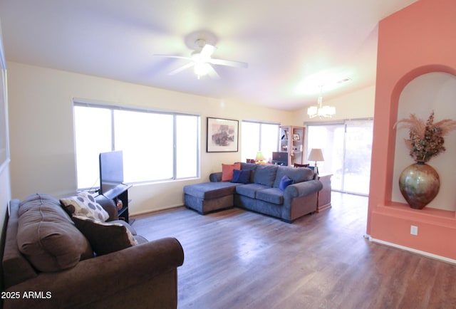 living room with ceiling fan with notable chandelier, wood-type flooring, and vaulted ceiling