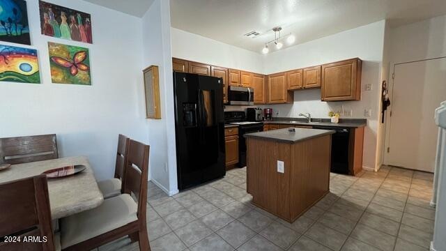 kitchen featuring a kitchen island, sink, light tile patterned floors, and black appliances