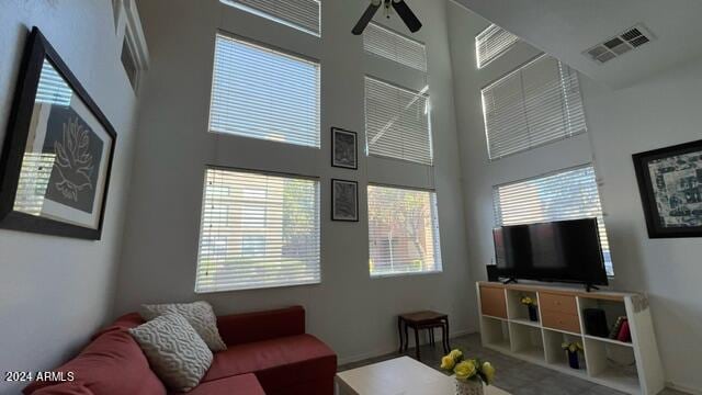 living room with ceiling fan and a high ceiling