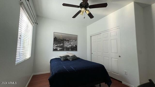 bedroom featuring dark hardwood / wood-style floors, ceiling fan, and a closet