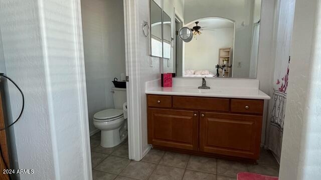 bathroom with ceiling fan, tile patterned floors, toilet, and vanity