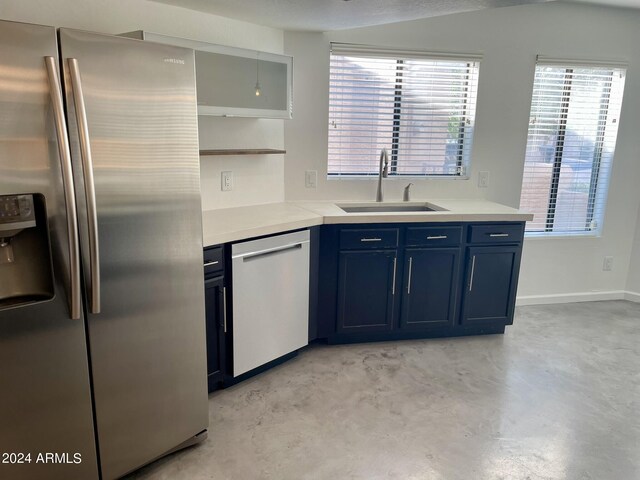 kitchen featuring stainless steel appliances, sink, and blue cabinetry