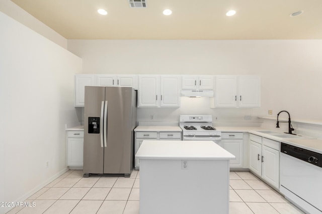 kitchen with a kitchen island, white cabinetry, sink, light tile patterned floors, and white appliances