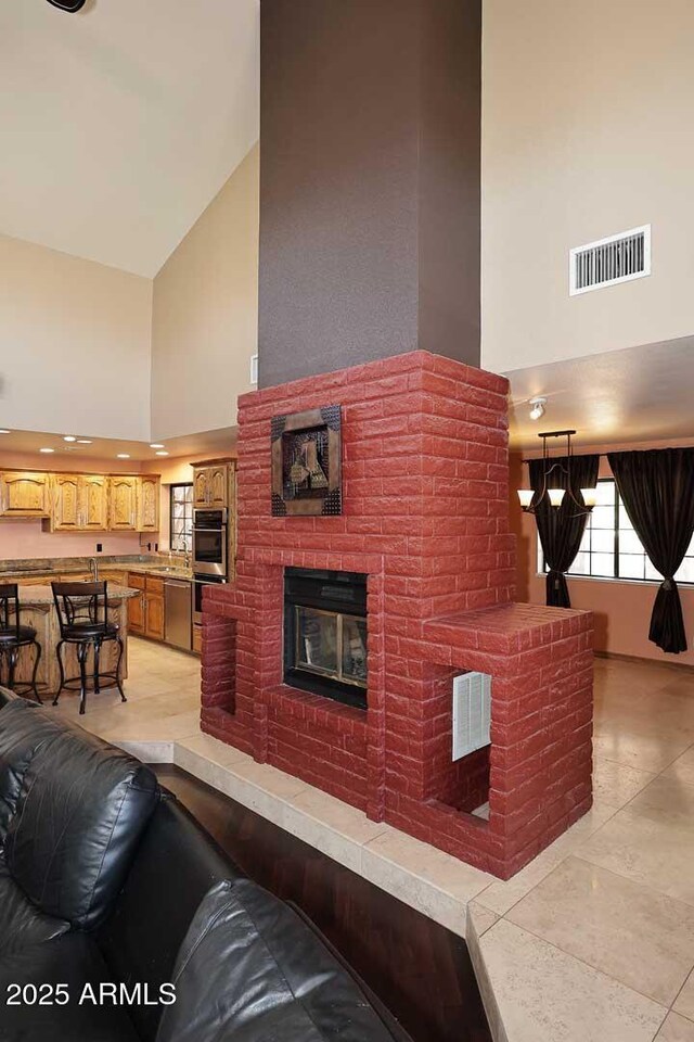 11215 N Garland Cir, Fountain Hills, AZ 85268 - living area with visible vents, a fireplace, light tile patterned floors, and high vaulted ceiling