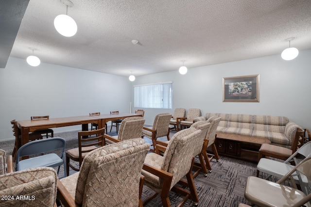 interior space with dark colored carpet and a textured ceiling