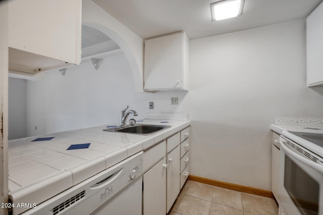 kitchen with white cabinetry, tile counters, light tile patterned flooring, and sink