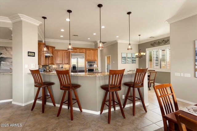 kitchen featuring decorative light fixtures, a kitchen bar, stainless steel built in fridge, light tile patterned floors, and kitchen peninsula