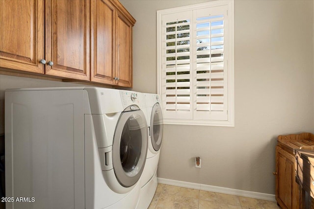 washroom with cabinets, washing machine and clothes dryer, and light tile patterned floors