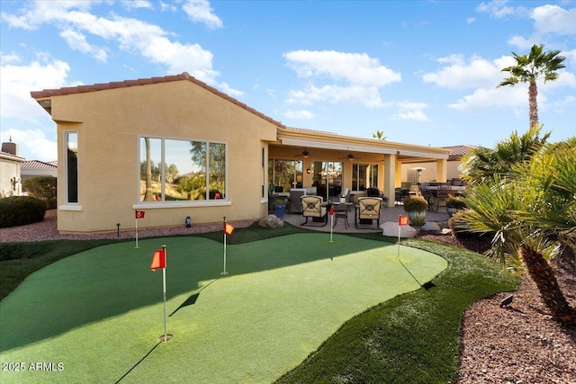 rear view of house with ceiling fan and a patio area