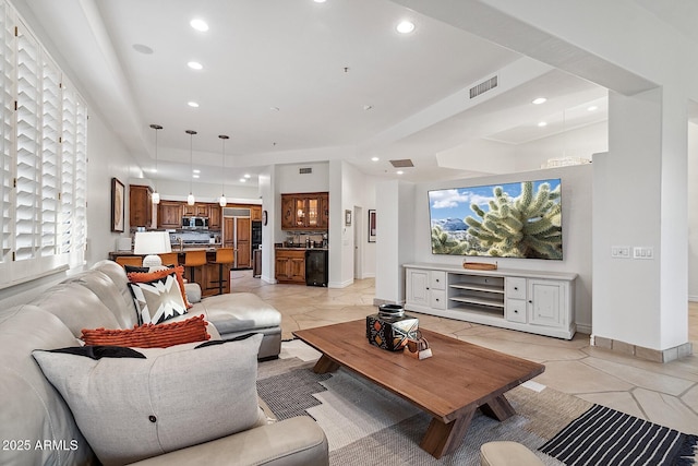 living area featuring baseboards, visible vents, and recessed lighting