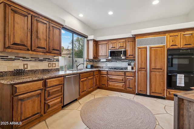 kitchen featuring brown cabinets, recessed lighting, backsplash, appliances with stainless steel finishes, and a sink