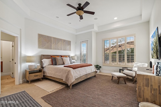 bedroom featuring light carpet, a tray ceiling, baseboards, and recessed lighting