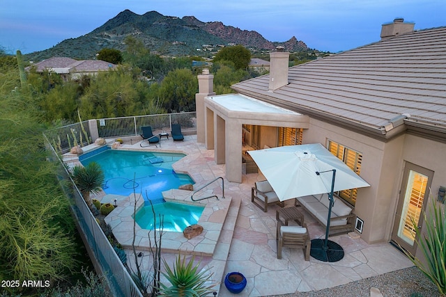 view of pool featuring a fenced in pool, a patio, an in ground hot tub, fence, and a mountain view