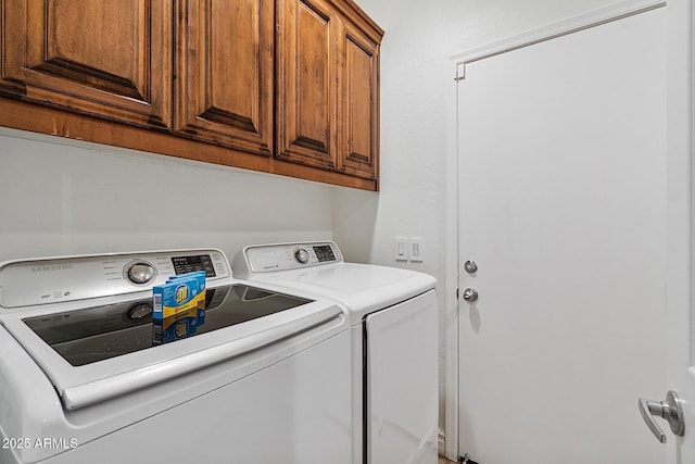 washroom with washing machine and clothes dryer and cabinet space