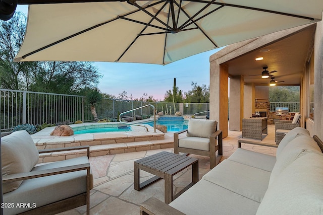 patio terrace at dusk featuring an outdoor living space with a fireplace, a fenced backyard, a ceiling fan, and a fenced in pool