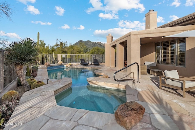 view of pool featuring an in ground hot tub, a patio, fence, and a fenced in pool