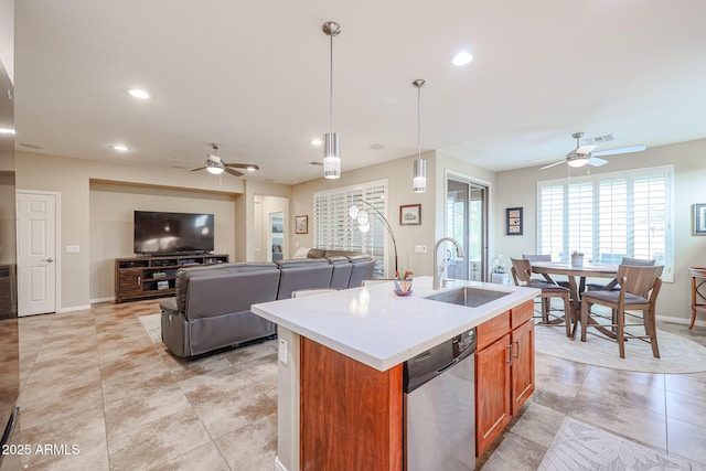 kitchen featuring a center island with sink, sink, pendant lighting, ceiling fan, and stainless steel dishwasher