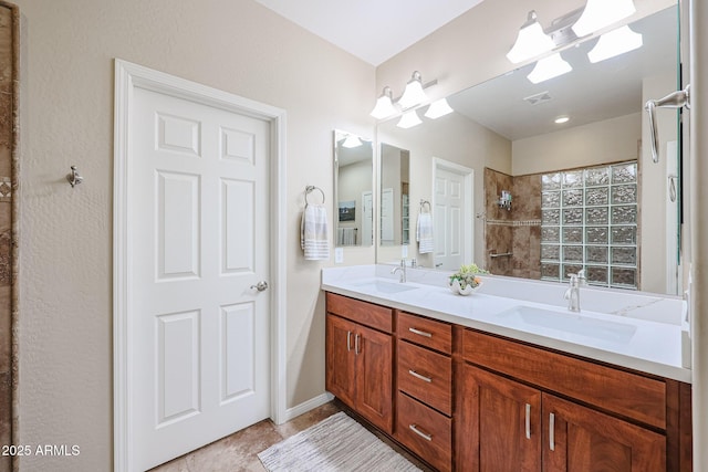 bathroom featuring a tile shower and vanity