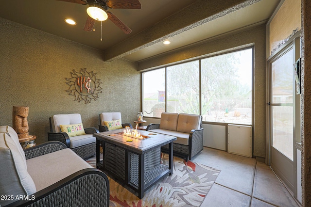 sunroom / solarium with ceiling fan, a wealth of natural light, and beam ceiling