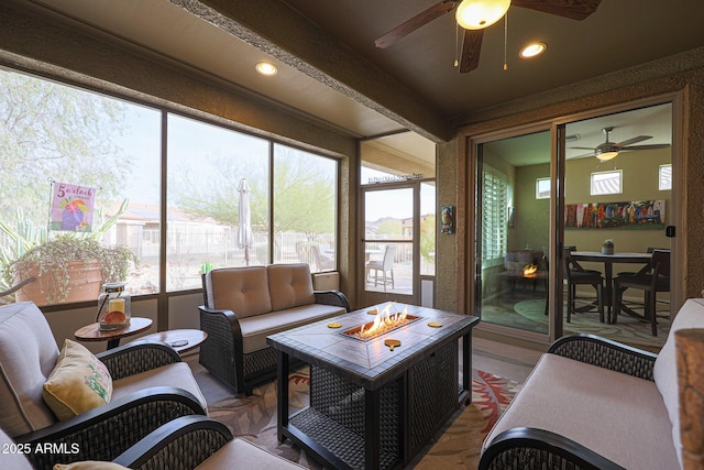 sunroom featuring ceiling fan and beam ceiling