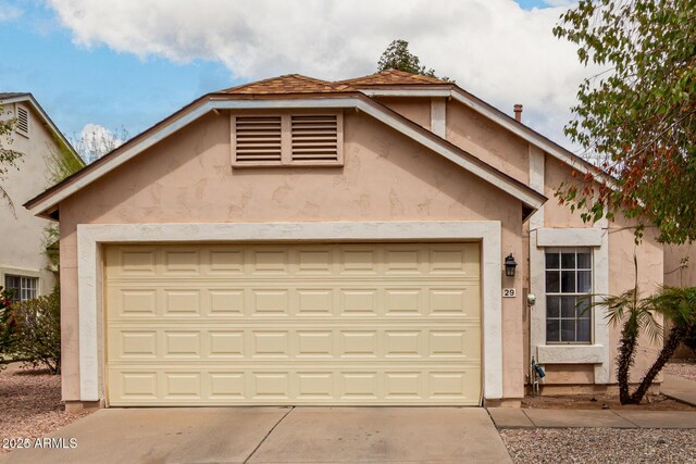 view of front facade featuring stucco siding, concrete driveway, and a garage