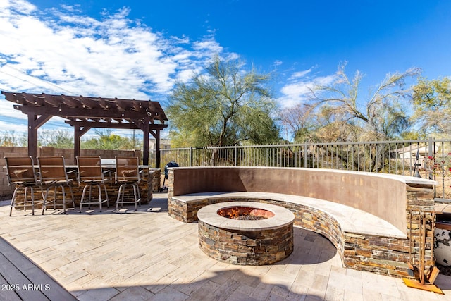 view of patio / terrace with exterior bar, a pergola, and an outdoor fire pit