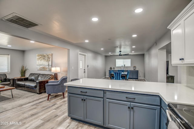 kitchen with ceiling fan, white cabinets, and light wood-type flooring