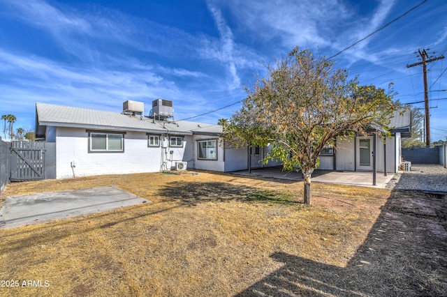 view of front of home with a front yard, a patio area, and central air condition unit