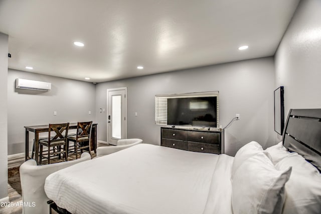 bedroom with hardwood / wood-style floors and a wall unit AC