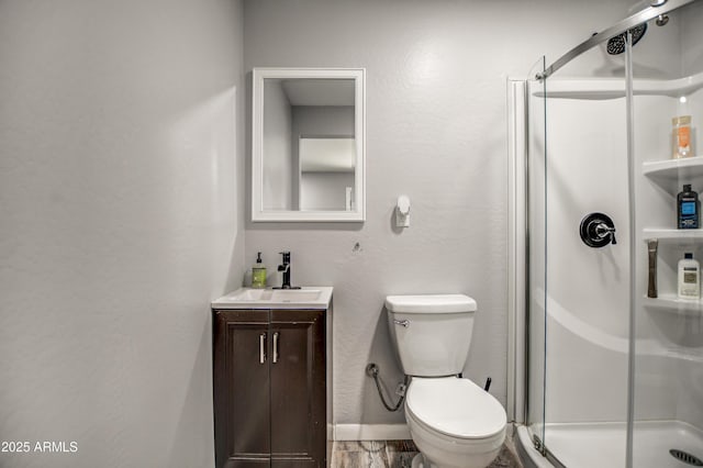 bathroom with vanity, a shower with shower door, and toilet