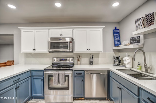 kitchen with sink, stainless steel appliances, white cabinets, and blue cabinetry