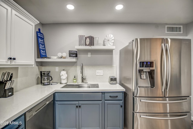 kitchen featuring appliances with stainless steel finishes, sink, decorative backsplash, and white cabinets