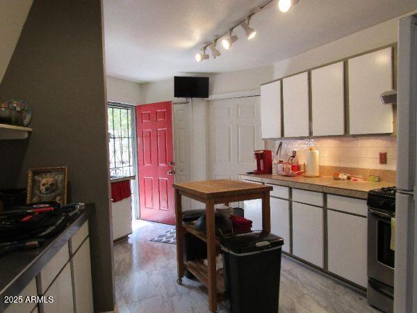 474 N Meadow Way, Payson, AZ 85541 - kitchen with range with gas stovetop, white cabinetry, backsplash, and under cabinet range hood
