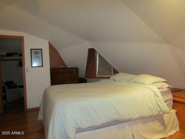 474 N Meadow Way, Payson, AZ 85541 - bedroom with a spacious closet, wood finished floors, vaulted ceiling, and a closet