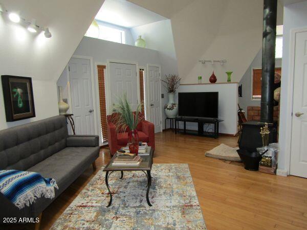 474 N Meadow Way, Payson, AZ 85541 - living area with vaulted ceiling, wood finished floors, a wood stove, and rail lighting