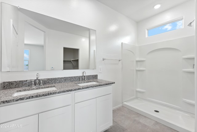 bathroom featuring walk in shower and vanity