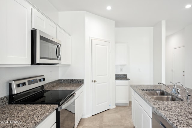 kitchen featuring white cabinetry, sink, stone counters, and appliances with stainless steel finishes