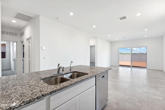 kitchen with white cabinetry, stainless steel dishwasher, sink, and stone counters