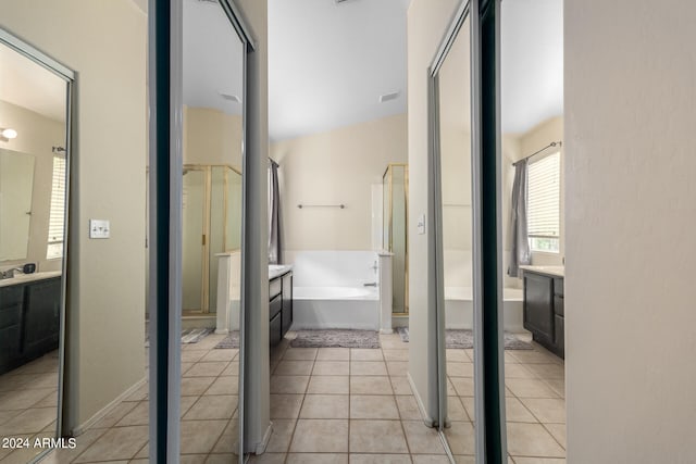 bathroom with tile patterned flooring, shower with separate bathtub, vanity, and vaulted ceiling