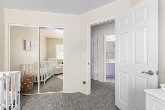 carpeted bedroom featuring a crib and a closet