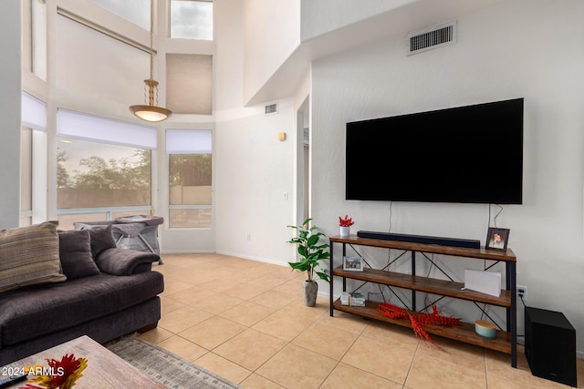 living room with a high ceiling and light tile patterned floors