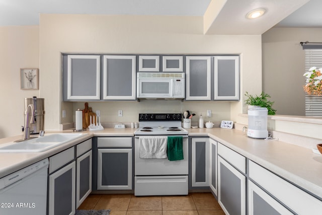 kitchen featuring gray cabinets, white appliances, sink, and light tile patterned floors