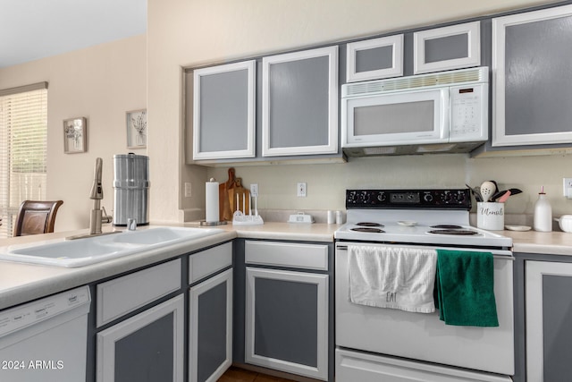 kitchen featuring white appliances, gray cabinets, and sink