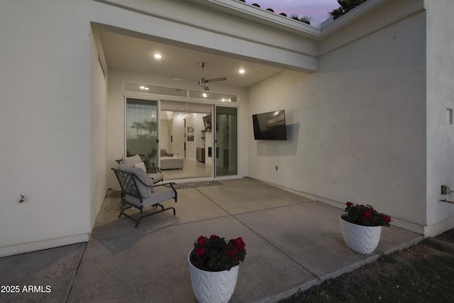 patio terrace at dusk featuring ceiling fan