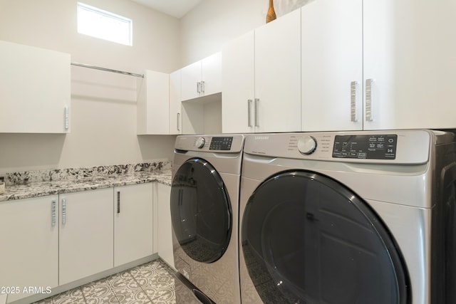 laundry room featuring washer and clothes dryer and cabinet space