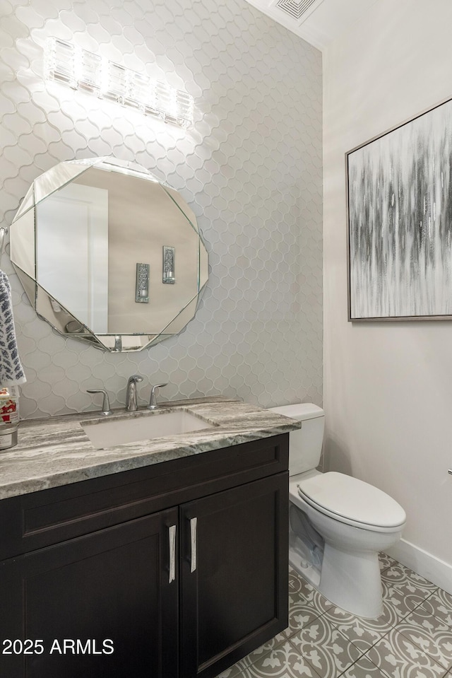 half bath featuring backsplash, vanity, toilet, and tile patterned floors